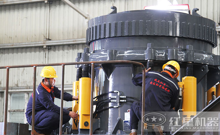 工作人員檢測圓錐破碎機(jī)，保障生產(chǎn)的設(shè)備都有高質(zhì)量